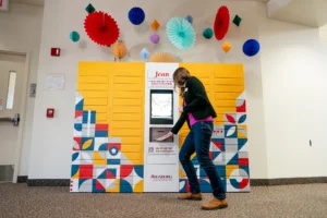 A student retrieves books from the Jean remoteLocker system at Augsburg University Library, highlighting flexible, self-service access for students.